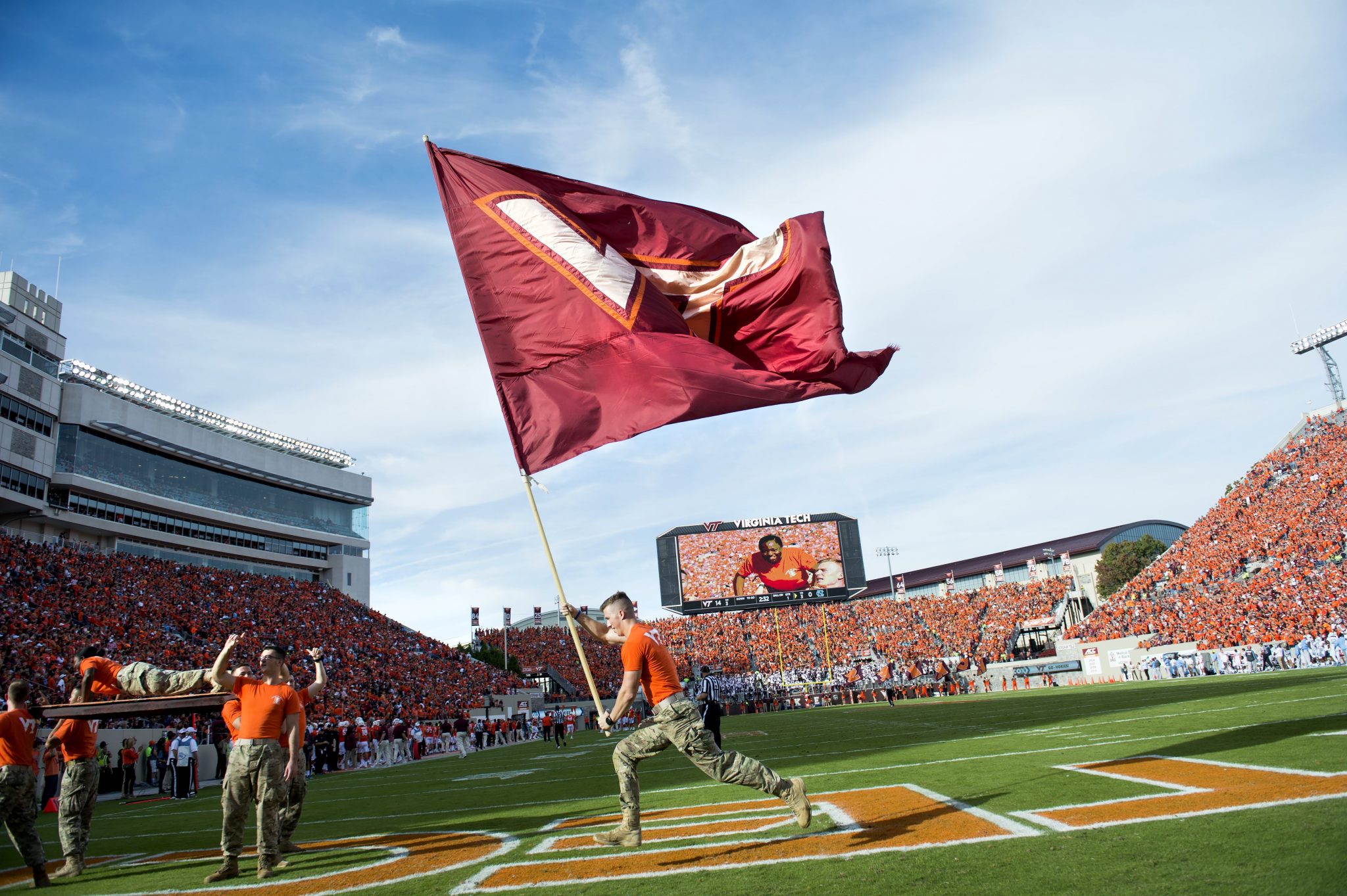 Corp of Cadets member waves VT flag at Lane Stadium, the largest stadium in VA