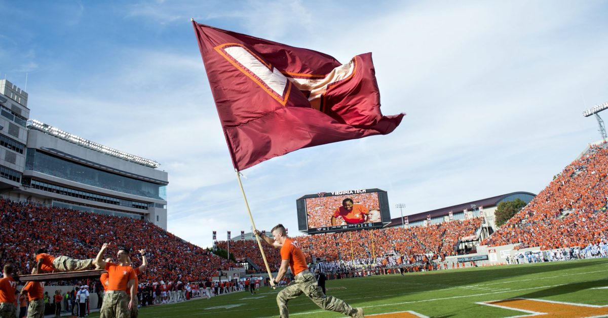 Corp of Cadets member waves VT flag at Lane Stadium, the largest stadium in VA