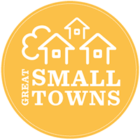 Yellow Great Small Towns Logo with houses and a comfortable feel. Given to Floyd County, VA a great small town near DC